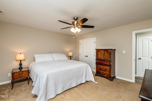 bedroom with baseboards, light colored carpet, and a closet