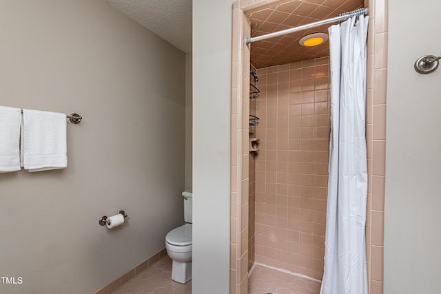 full bathroom featuring tile patterned flooring, baseboards, a tile shower, and toilet