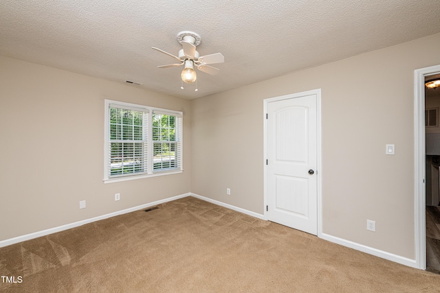 unfurnished bedroom featuring visible vents, carpet flooring, baseboards, and a ceiling fan