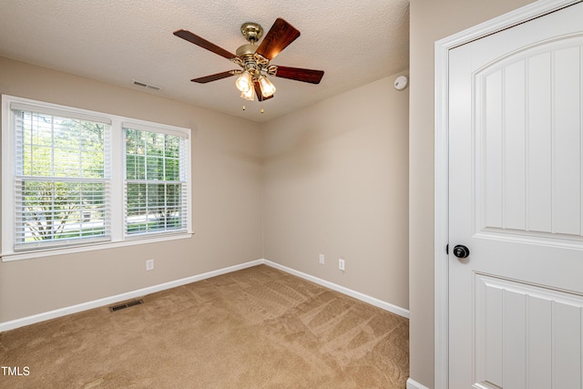 empty room featuring visible vents, a ceiling fan, baseboards, and light colored carpet
