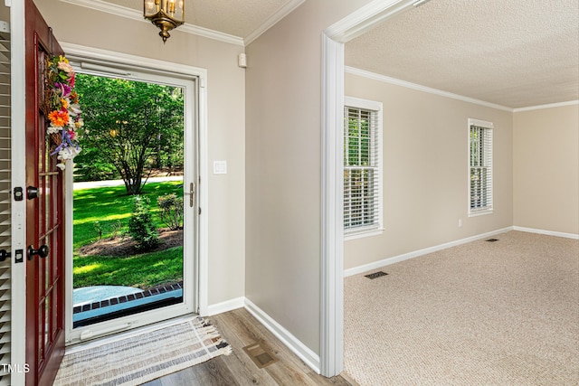 entrance foyer featuring crown molding, baseboards, a textured ceiling, and visible vents