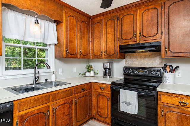 kitchen featuring light countertops, under cabinet range hood, brown cabinets, a sink, and black appliances