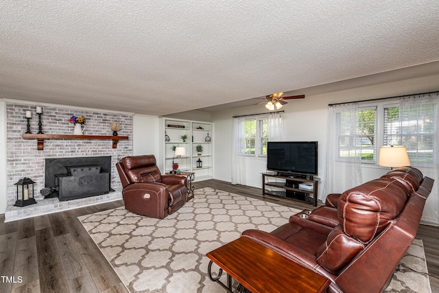 living area with a ceiling fan, a textured ceiling, and wood finished floors