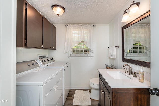 bathroom with a textured ceiling, baseboards, vanity, toilet, and washer and clothes dryer