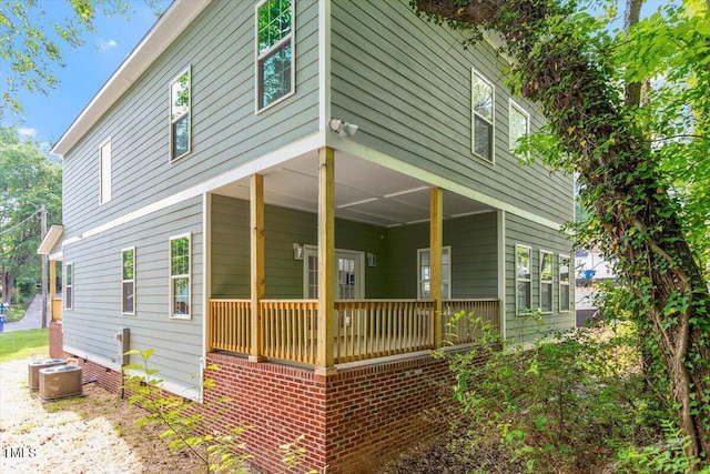view of side of property with central air condition unit and covered porch