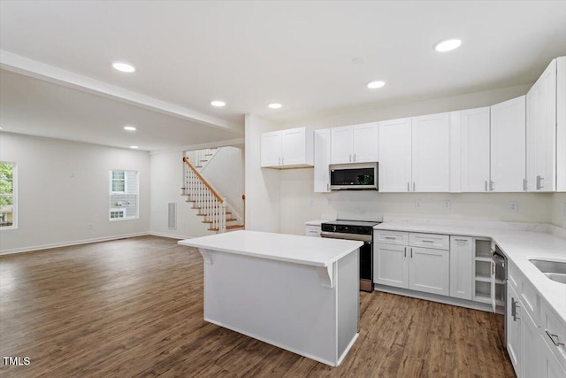 kitchen featuring light countertops, dark wood-style flooring, appliances with stainless steel finishes, and white cabinets