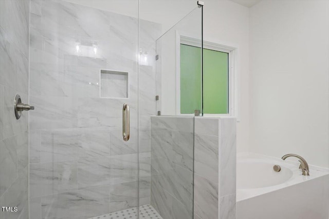bathroom featuring a shower stall and a bath