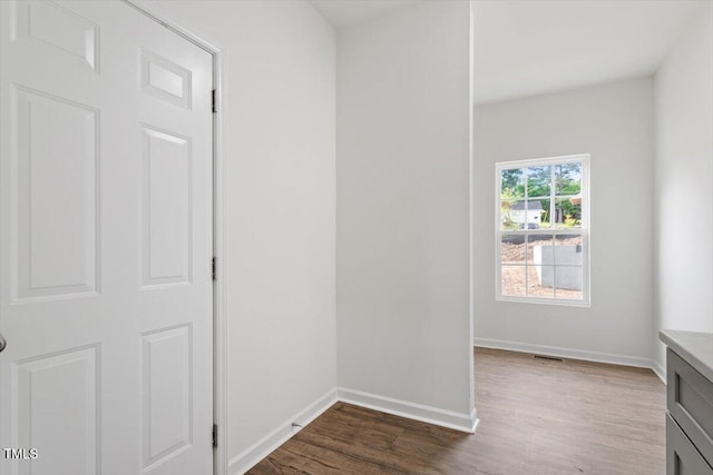 corridor with baseboards, dark wood-style floors, and visible vents