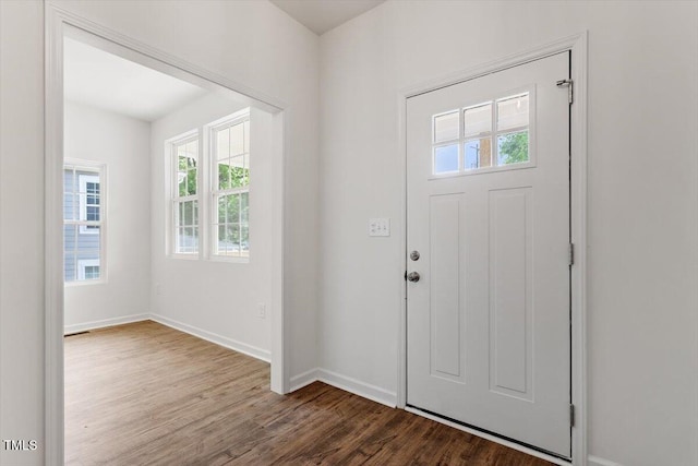 foyer featuring baseboards and wood finished floors