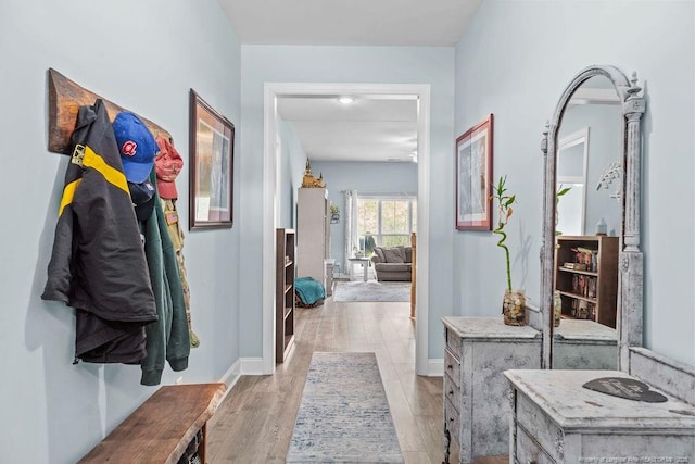 hallway featuring baseboards and light wood finished floors