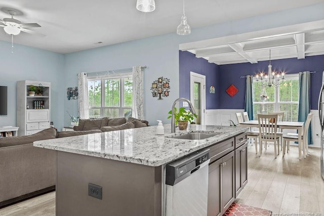 kitchen featuring beam ceiling, a sink, light wood finished floors, stainless steel dishwasher, and coffered ceiling