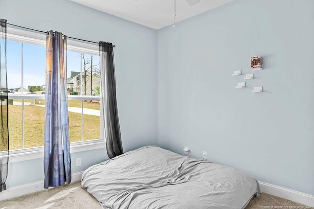 bedroom featuring baseboards, carpet floors, and multiple windows
