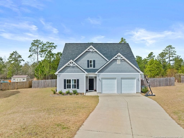 craftsman house featuring concrete driveway, an attached garage, fence, and a front yard