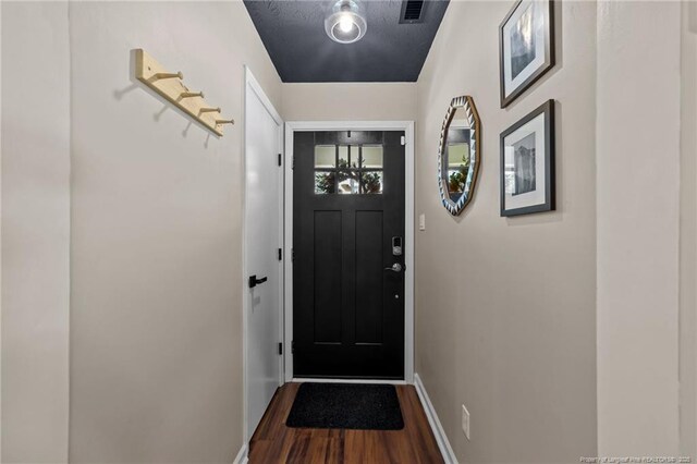 entryway with baseboards, wood finished floors, and visible vents