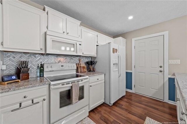 kitchen featuring tasteful backsplash, dark wood-style flooring, white appliances, and white cabinets
