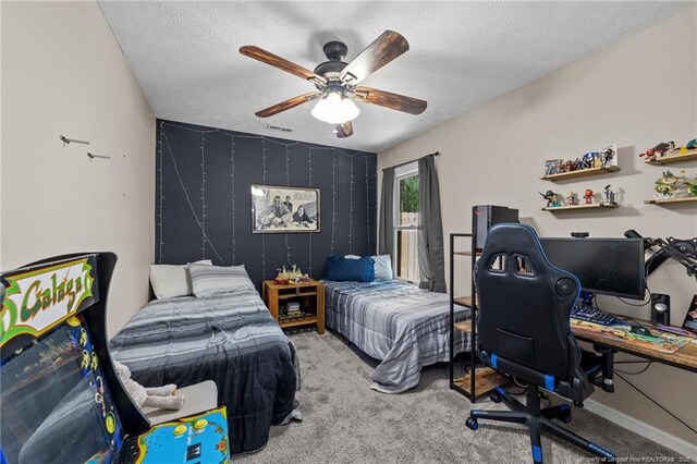 carpeted bedroom featuring baseboards, ceiling fan, a textured ceiling, and visible vents