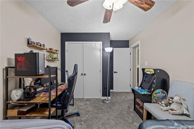 carpeted bedroom featuring a closet, a textured ceiling, and ceiling fan