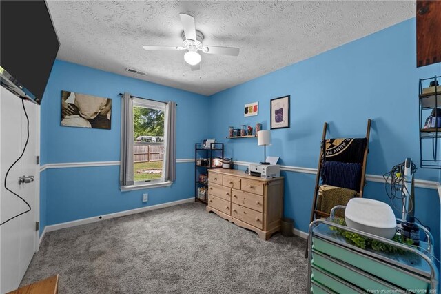 carpeted bedroom featuring visible vents, a ceiling fan, a textured ceiling, and baseboards