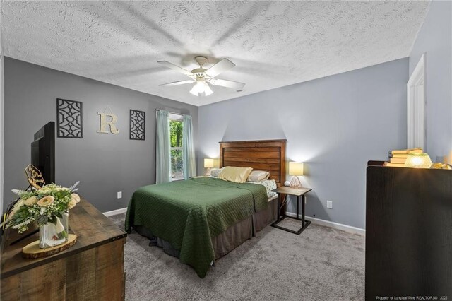 bedroom with baseboards, carpet flooring, a textured ceiling, and a ceiling fan