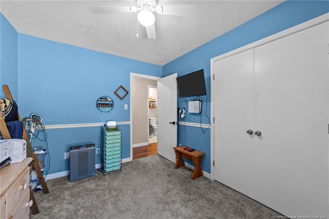 carpeted bedroom featuring baseboards, a ceiling fan, a textured ceiling, and a closet