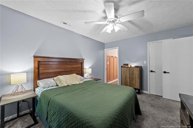 bedroom with ceiling fan, carpet flooring, a textured ceiling, and visible vents