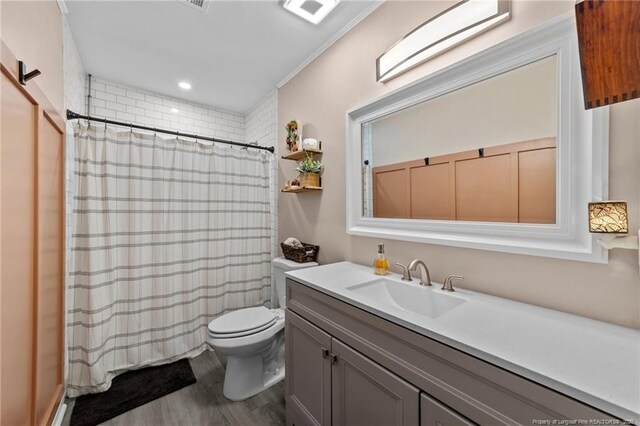 bathroom featuring visible vents, curtained shower, wood finished floors, vanity, and toilet