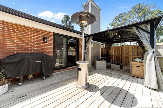 wooden terrace featuring a gazebo and area for grilling