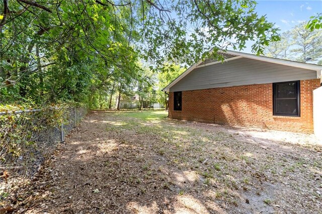 view of home's exterior with a fenced backyard and brick siding