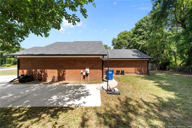 rear view of house with a lawn, brick siding, and fence