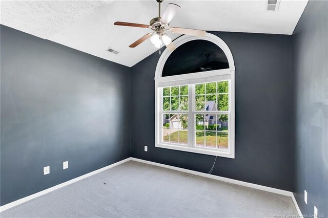 carpeted empty room with baseboards, a ceiling fan, lofted ceiling, and visible vents