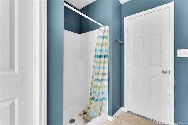 full bathroom with baseboards, a shower stall, and tile patterned flooring