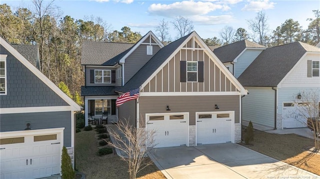 craftsman-style house with concrete driveway, board and batten siding, and stone siding