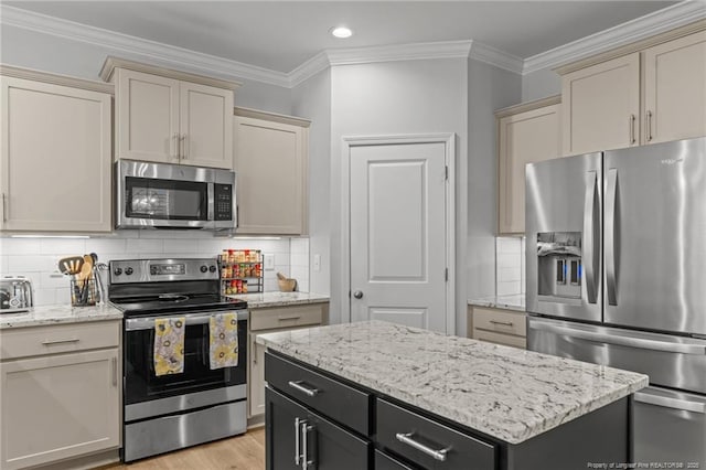 kitchen with ornamental molding, backsplash, cream cabinets, and stainless steel appliances