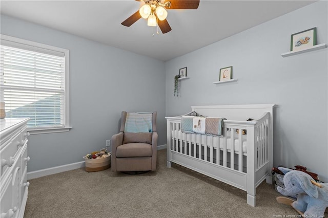bedroom with baseboards, carpet, ceiling fan, and a nursery area