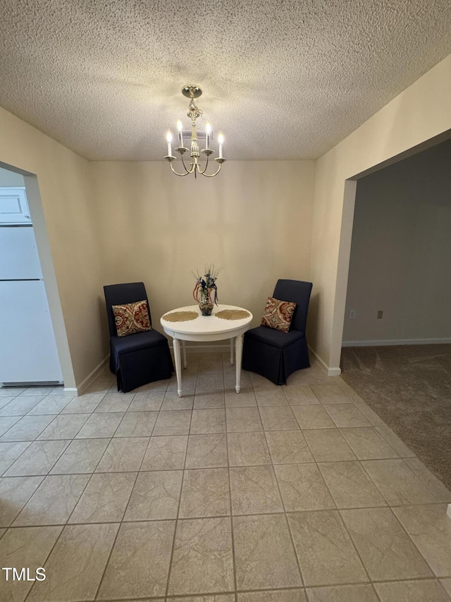 living area featuring baseboards, a textured ceiling, and a notable chandelier