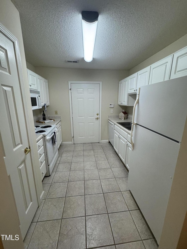 kitchen featuring light countertops, white appliances, white cabinetry, and visible vents