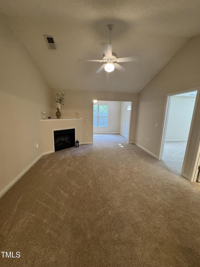 unfurnished living room with carpet floors, a fireplace, baseboards, ceiling fan, and vaulted ceiling