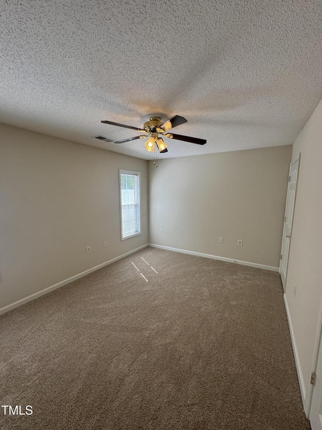 empty room featuring carpet floors, a ceiling fan, and baseboards