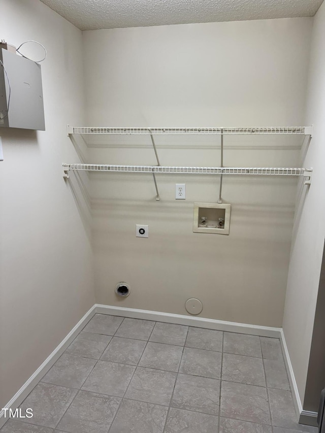 clothes washing area featuring laundry area, tile patterned flooring, baseboards, hookup for a washing machine, and hookup for an electric dryer