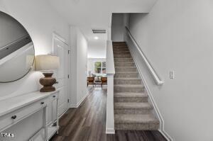 stairs with baseboards, visible vents, and wood finished floors