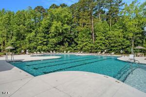 pool featuring a patio and a wooded view