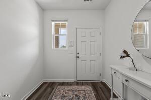 doorway to outside with baseboards, plenty of natural light, and dark wood-type flooring