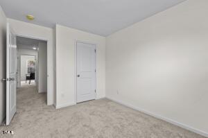 unfurnished bedroom with baseboards and carpet
