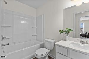 bathroom with vanity, shower / bathing tub combination, and toilet