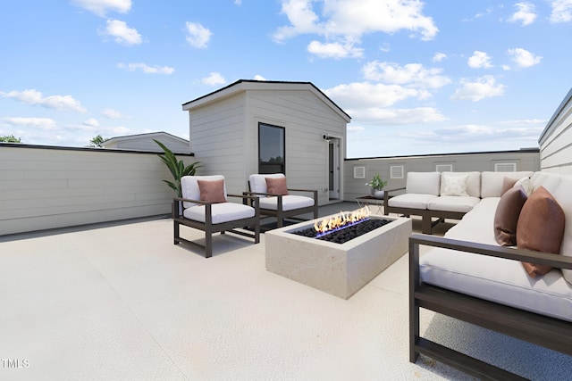 view of patio with an outdoor living space with a fire pit