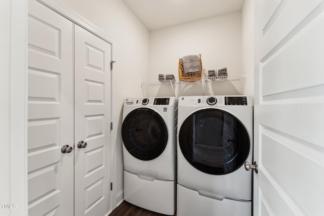 clothes washing area featuring laundry area, dark wood-style flooring, and washer and dryer