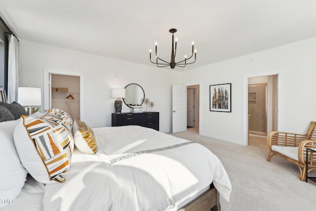 bedroom with a chandelier, a closet, a spacious closet, ensuite bathroom, and light carpet