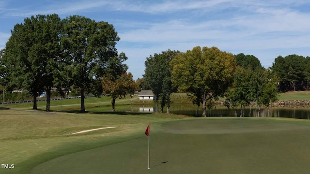 view of home's community featuring a water view, view of golf course, and a yard