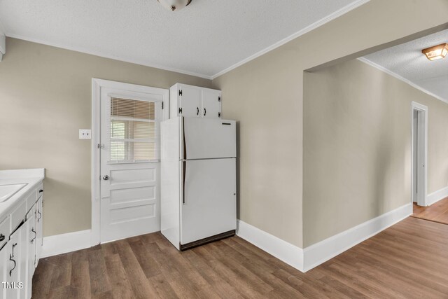 2677 NC-39, Henderson, NC 27537 - kitchen featuring freestanding refrigerator, a textured ceiling, dark wood-style floors, and ornamental molding