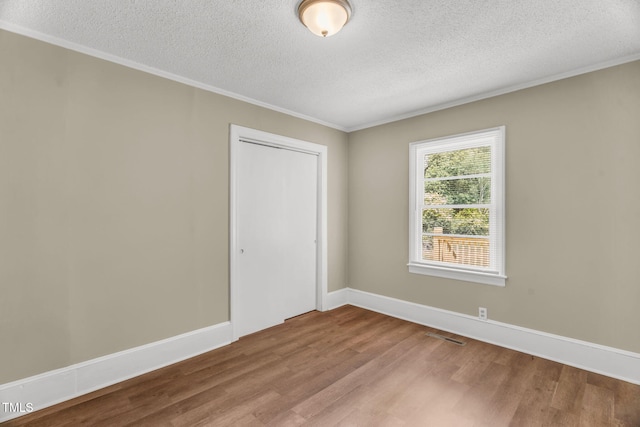 2677 NC-39, Henderson, NC 27537 - spare room featuring a textured ceiling, visible vents, ornamental molding, and wood finished floors